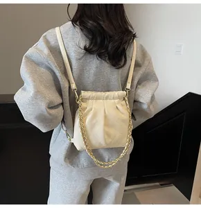 Detail of quilted bucket backpack with cream PU leather and gold chain drawstring