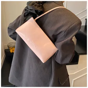 Pink leather shoulder bag with ZSKE lettering shown on model in a minimalist setting