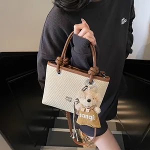 Fashion woven bucket bag with brown leather trim and a cute teddy bear charm