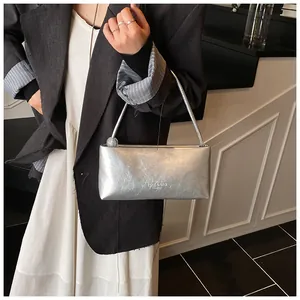 Close-up of silver pleated underarm bag with thin shoulder strap and bead detail
