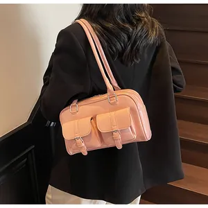 Detail of pink glossy patent leather tote bag with dual front buckle pockets and silver hardware