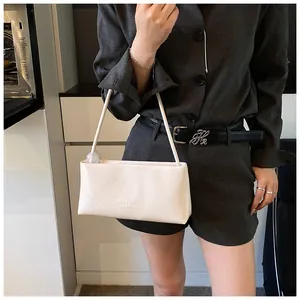 Detail of white rectangular PU leather bag with transparent sphere ornament on strap