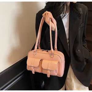 Close-up of pink glossy leather tote with dual utility pockets and long shoulder straps