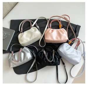 Top view of pleated cloud bags in five colors with woven handles and long straps