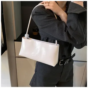 Detail of white minimalist underarm bag with decorative transparent ball and embossed logo