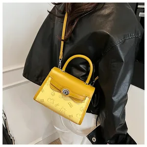 Detail of contrast yellow crossbody bag featuring bear print and metal turn-lock closure