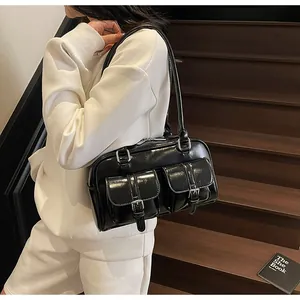 Detail of black glossy bowling bag with double pockets on model with minimalist style