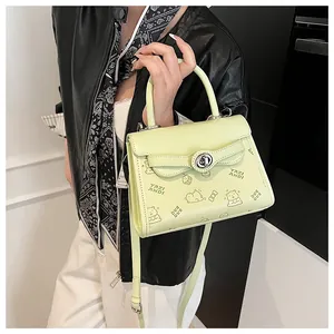 Detail of light green mini bag with cartoon bear print and silver twist lock closure