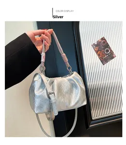 Detail of silver pleated cloud bag with metallic texture and rope handle shown by model