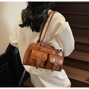 Detail of retro brown PU leather shoulder bag with dual flap pockets and silver buckles