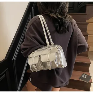 Detail of silver metallic shoulder bag with double buckle pockets and glossy leather finish