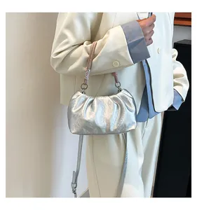 Fashionable silver pleated cloud bag with pink handle and slim crossbody strap