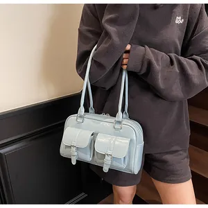 Close-up of light blue patent leather tote bag with double front pocket buckles