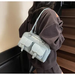 Detail of light blue glossy tote bag with dual front utility pockets and silver buckles