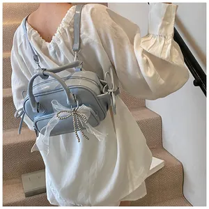 Mini mochila azul claro de piel sintética con lazos de malla blanca usada por modelo