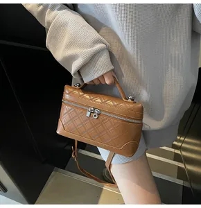 Close-up of brown quilted faux leather handbag featuring metal lock and key charm detail