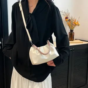 Elegant white ruched cloud handbag with colorful woven handle and leather shoulder strap