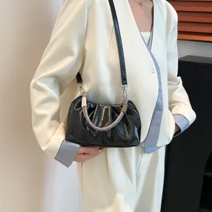 Modern black pleated cloud bag with a colorful woven handle and leather shoulder strap