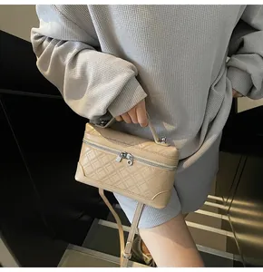 Detailed view of beige crossbody square bag with diamond quilt texture and top handle