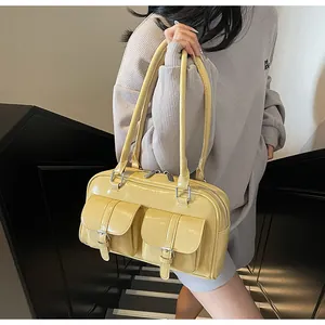 Detail of light yellow glossy shoulder bag with double pockets and silver buckles