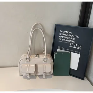 Macro shot of cream bowling tote bag with glossy finish and two front buckle flap pockets