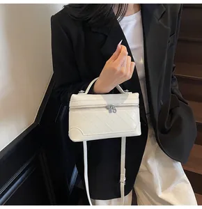 Quilted white vanity crossbody bag with silver zipper detail and slim shoulder strap