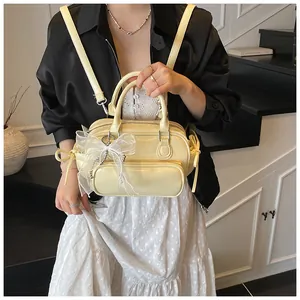 Detalle de mochila de cuero PU amarillo crema con lazo de encaje y cadena de perlas