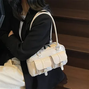 Off-white glossy patent leather tote bag with dual front pockets on model