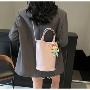 Detailweergave van de roze emmertas met cartoon hanger en reliëf tekst op de achterkant
