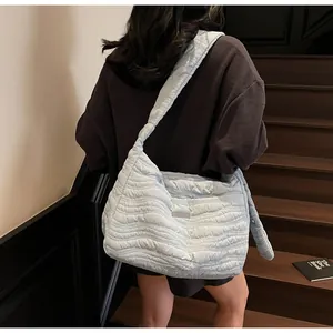 Détail du sac cabas matelassé bleu clair avec couture ondulée et bandoulière large