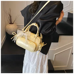 Detalle de bolso amarillo claro con lazo de organza blanca y correa ajustable