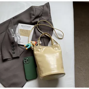 Detail van beige bucket bag met krokodillenpatroon, modehanger en handvat bovenaan