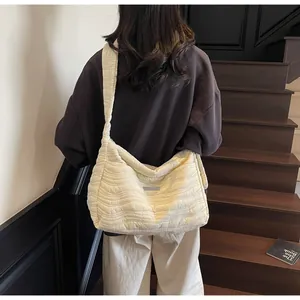 Détail du sac fourre-tout matelassé crème avec texture ondulée et bandoulière