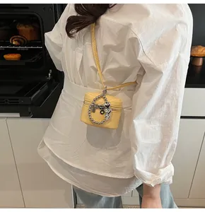 Detail view of mini yellow leather crossbody bag with silver heart bead chain