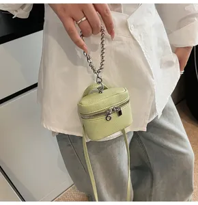 Detail of pistachio green litchi leather mini bag with metal bead chain and strap