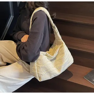 Détail du sac fourre-tout blanc crème avec matelassage ondulé et large bandoulière