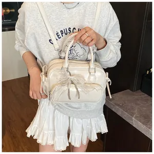 Detalle de la mochila de PU crema con lazo de malla, perlas y acabado brillante
