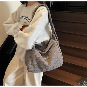 Vue détaillée du grand sac cabas matelassé gris avec bandoulière large et boucle en métal