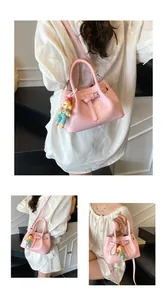 Detailed view of pink glossy bucket bag with pearl chain and cute cartoon charm
