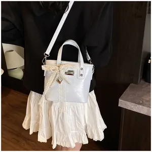 Dettaglio della mini borsa a mano con elegante pizzo e decorazione con fiocco di perle