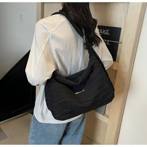 Détail d'un grand sac fourre-tout noir matelassé avec tissu texturé et bandoulière