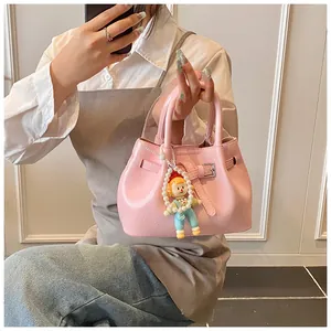 Detailed shot of pink pleated bucket bag with pearl charm and cute doll pendant handle