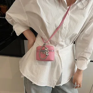 Pink lychee leather crossbody bag with silver heart chain accessory and zip closure