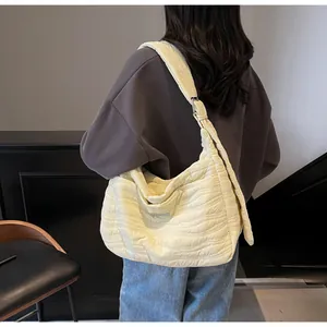 Détail du tissu matelassé et de la boucle métallique réglable sur le sac à bandoulière