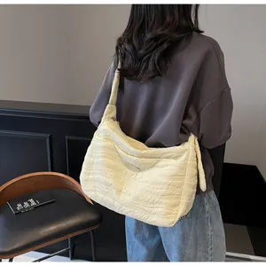 Détail du sac cabas beige matelassé avec coutures ondulées et large bandoulière