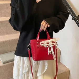 Elegante borsa a tracolla in pelle verniciata rossa con fiocco di pizzo e perle
