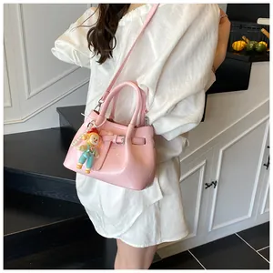 Pink patent leather bucket bag featuring decorative pearl chain and cute cartoon charm