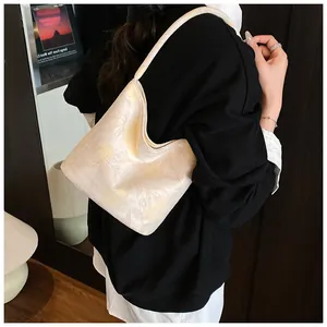 Detailed view of beige floral jacquard shoulder bag showing fabric texture and crescent shape