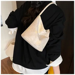 Detail of off-white bucket bag with yellow floral jacquard and geometric structure