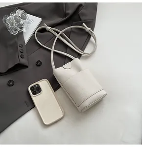 Close-up of litchi texture on off-white crossbody phone bag with a stylish strap